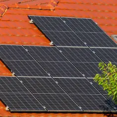 Panele fotowoltaiczne na dachu, zbierające energię słoneczną. OSD to skrót od "Odnawialne Źródła Energii", które te panele reprezentują.