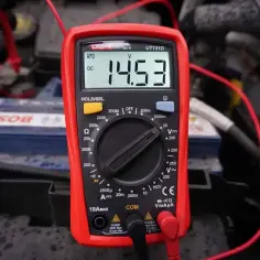 Multimetr pokazuje 14.53V, co jest kluczowe, jak sprawdzić przekaźnik. Pomiar napięcia na akumulatorze.