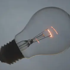 Żarówka z żarnikiem w środku, symbolizująca awarię prądu Tauron.