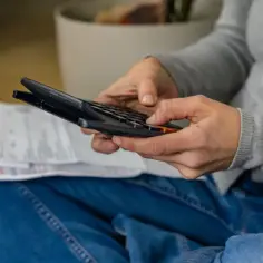 Osoba liczy rachunki na kalkulatorze, szukając informacji, jak zmienić taryfę w PGE.