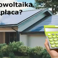 Dom z instalacją solarną na dachu, obok kalkulator. Czy fotowoltaika się opłaca?