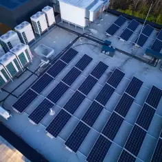Panele słoneczne i jednostki klimatyzacyjne na dachu. Systemy te, choć różne, współpracują, minimalizując reaktancję i optymalizując zużycie energii.