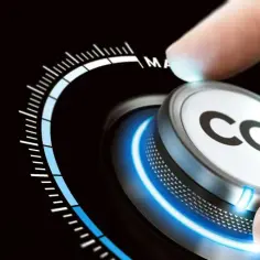 Dłoń obraca pokrętło z napisem CO2, zbliżając się do oznaczenia "MAX". Symbolizuje to dążenie do dekarbonizacji i ograniczenia emisji.