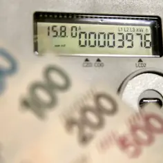 Liczniki energii i banknoty symbolizują koszty, w tym opłatę kogeneracyjną.