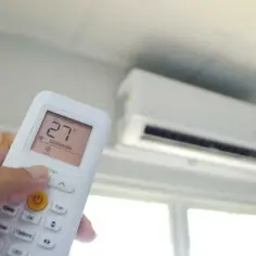 Pilot klimatyzatora ustawia temperaturę 27°C. Urządzenie zapewnia komfortowe ogrzewanie i chłodzenie.