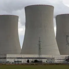Trzy wielkie chłodnie kominowe elektrowni atomowych w Niemczech, z których unosi się para.