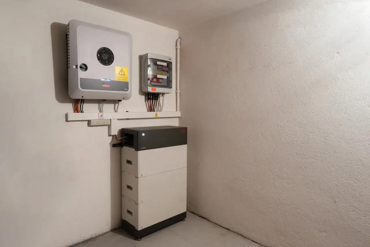 Nowoczesna instalacja fotowoltaiczna z magazynem energii BYD. Inwerter Fronius i skrzynka elektryczna zamontowane na ścianie.
