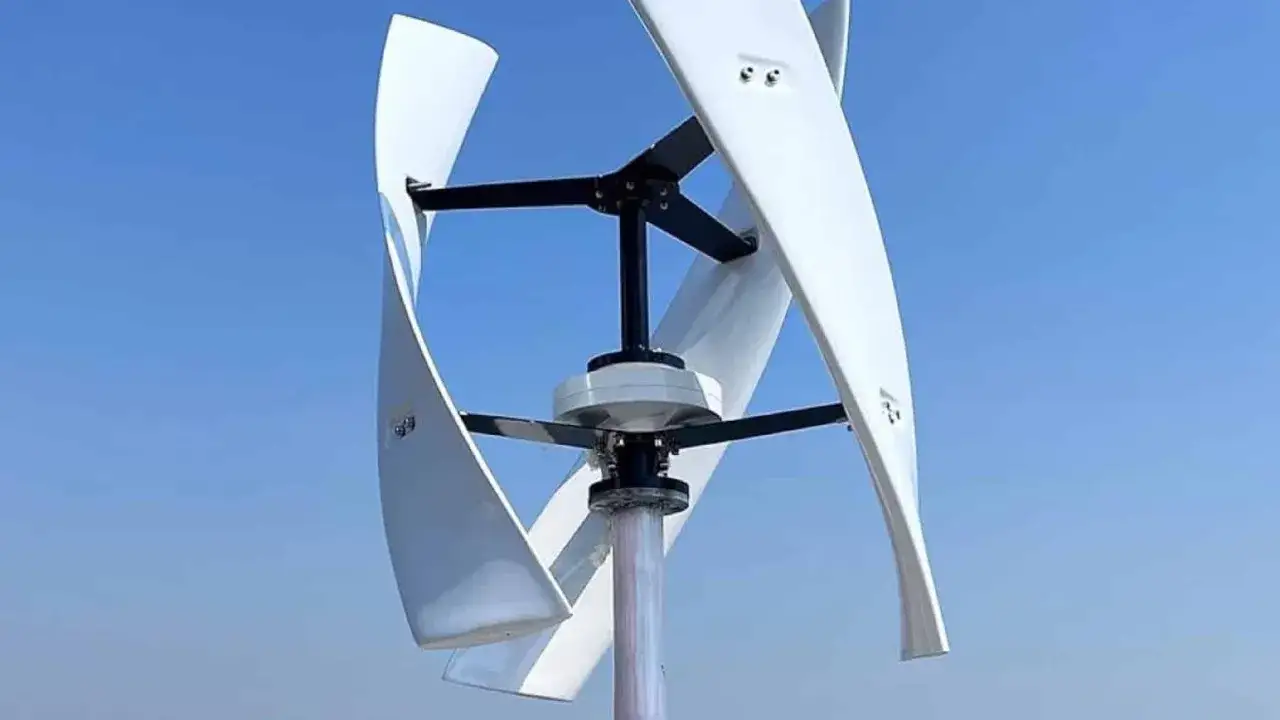 Białe, spiralne turbiny wiatrowe pionowe obracają się na tle błękitnego nieba, symbolizując czystą energię.